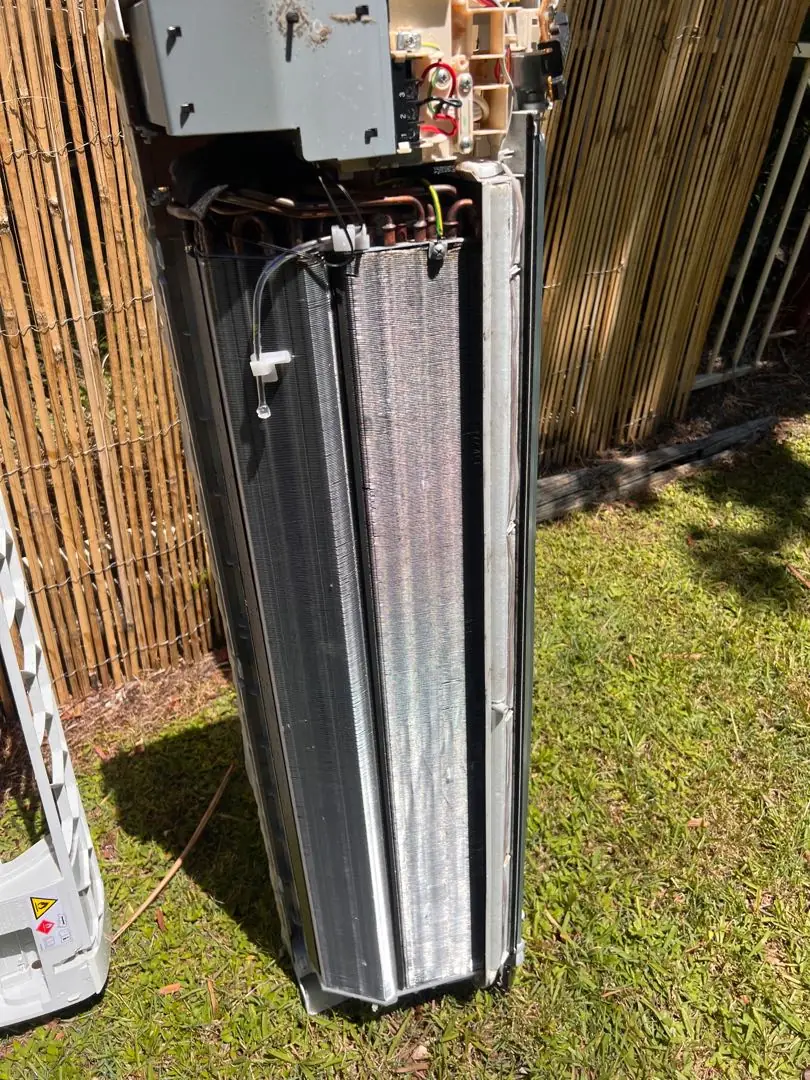 Indoor fan coil opened up with the casing off and the coil exposed for cleaning.