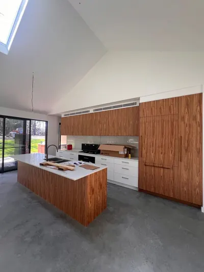 Linear supply vent above the cabinetry in a kitchen with a raked ceiling.