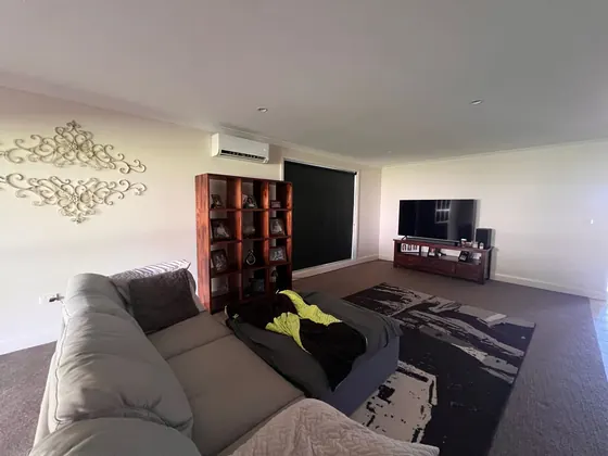 Split system head unit mounted above the lounge in a family living room.