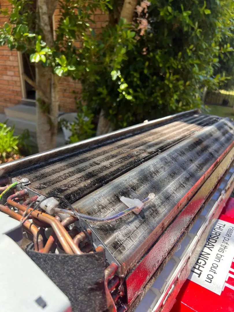 Ducted evaporator coil pulled out on a ute tray with copper pipework exposed.